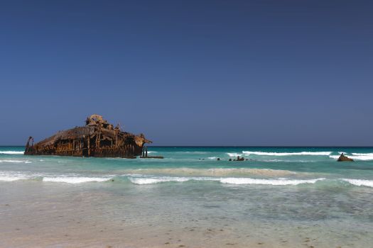 dois turistas a tirar fotografia junto do navio cabo de santa maria que afundou na praia da atalanta, na ilha da boa vista, em cabo verde